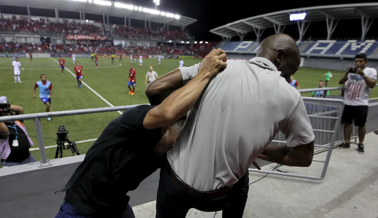 Pelatih tim nasional Kosta Rika, Paulo Wanchope (kanan) terlibat baku hantam dengan petugas keamanan di tribun stadion Maracana, Panama, 11 Agustus 2015. Setelah kejadian itu, Wanchope memutuskan mundur dari jabatannya. (REUTERS)