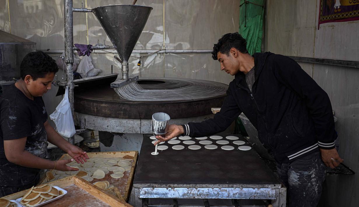 Kawasan Timur Tengah memiliki tradisi menikmati kue atau kudapan khas Ramadan, seperti Qatayef dan Kunafa. Tampak dalam foto, seorang pembuat dan pedagang roti Mesir membuat Qatayef, pancake tradisional yang dibuat selama bulan puasa suci Ramadan, di tokonya, Kairo, Mesir, pada Kamis 12 Maret 2026. (Khaled DESOUKI/AFP)