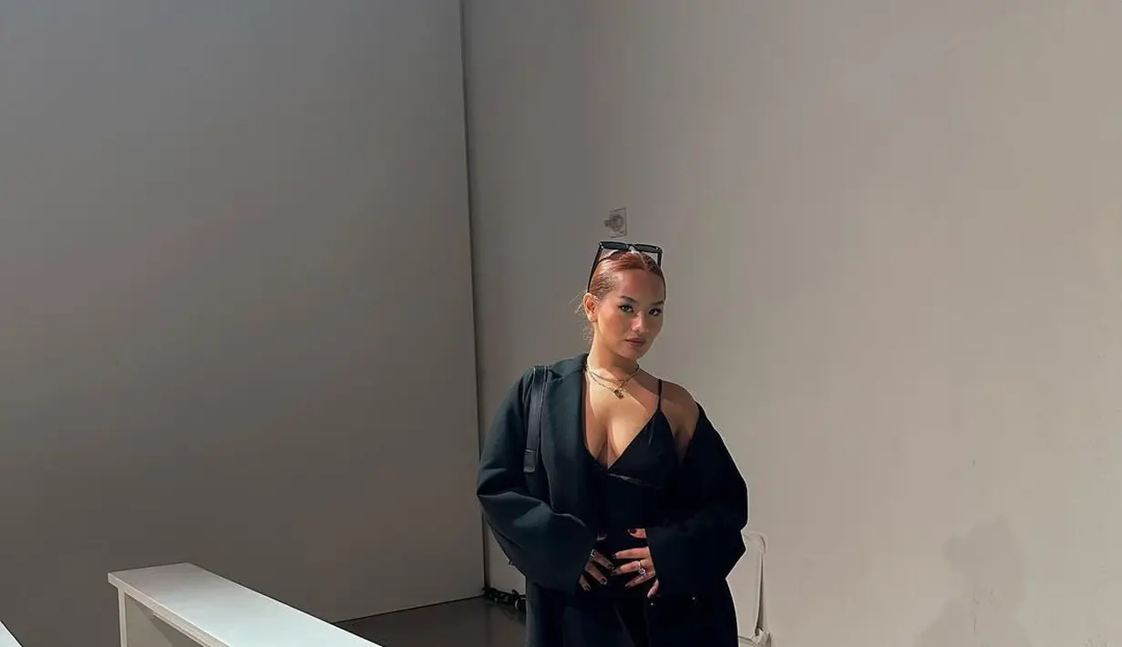 Penampilan Zahwa Massaid dengan outfit serba hitam. Ia mengenakan sebuah dress hitam bertali spageti yang ditumpuknya dengan trench coat yang juga berwarna hitam. [Foto: Instagram/zahwamassaid]