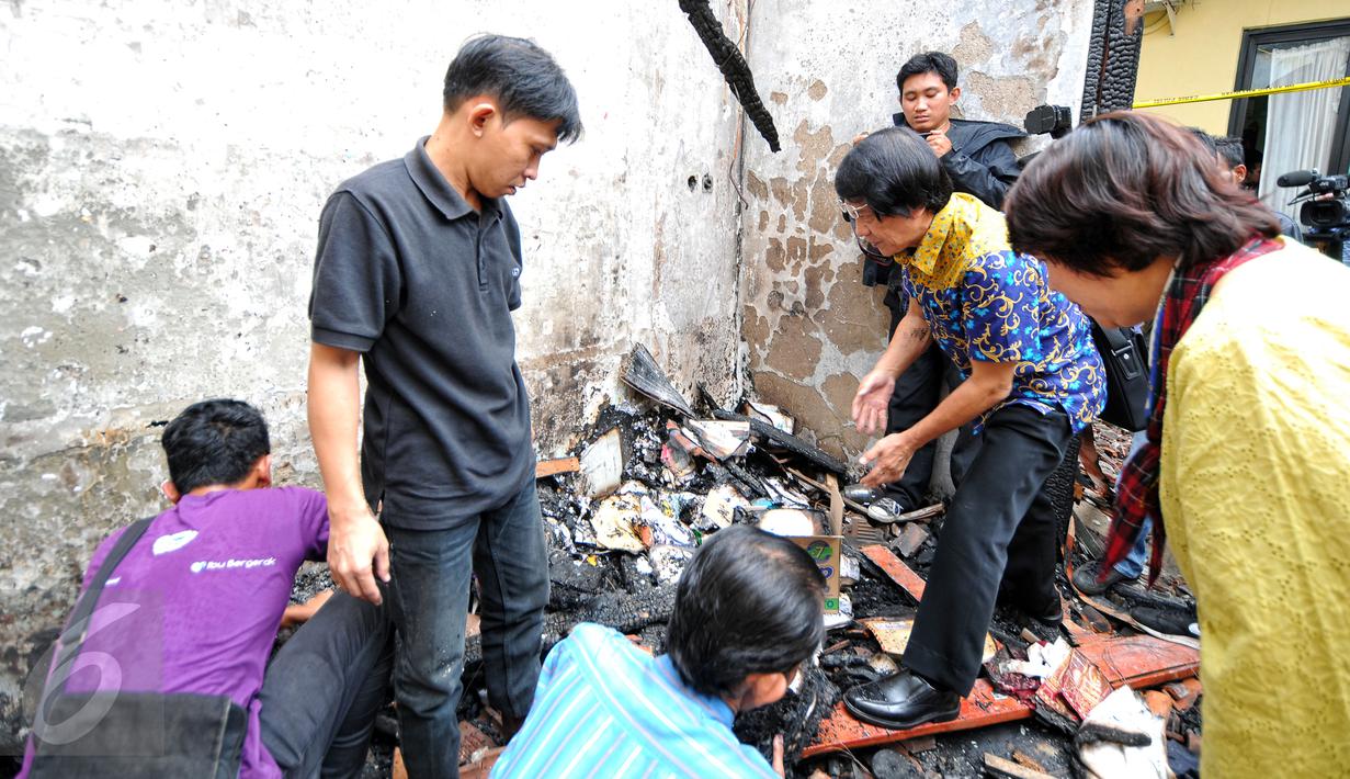 Ketua Komnas PA Seto Mulyadi (batik biru) bersama petugas Komnas PA lainnya mencari berkas yang bisa diselamatkan pasca-kebakaran di kantor tersebut pada 28 Juni lalu, di kawasan Pasar Rebo, Jakarta, Senin (29/6/2015). (Liputan6.com/Yoppy Renato)