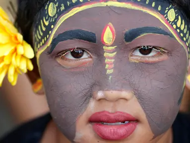 Seorang pemuda berpartisipasi dalam ritual Hindu "Grebeg" di Desa Tegallalang, Bali, Rabu (30/1). Dalam ritual dua tahunan ini, para pemuda berkeliling kampung dengan riasan tubuh warna-warni untuk menangkal Roh jahat. (AP/Firdia Lisnawati)
