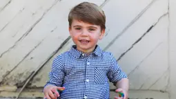 Pangeran Louis saat merayakan ulang tahunnya yang ke-2 di Inggris ( 22/4/2020). Pangeran Louis tampil lucu dengan mengenakan kemeja motif kotak-kotak berwarna biru dan putih di acara tersebut. (The Duchess of Cambridge / Kensington Palace via AP)