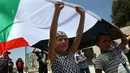 Foto yang diambil pada 10 Juni 2011 menunjukkan Ahed Tamimi memegang bendera nasional Palestina saat melakukan demonstrasi di Desa Nabi Saleh. Bagi keluarga Tamimi bukan kali ini saja mereka ditangkap oleh tentara Israel. (AFP Photo/Abbas Momani)