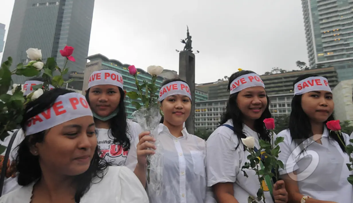 Dalam aksi damai "Save Polri" peserta aksi membagikan bunga mawar kepada warga, Bundaran HI, Jakarta, Minggu (1/2/2015). (Liputan6.com/Herman Zakharia)