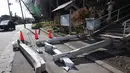 Gempa dengan kekuatan 7,5 magnitudo itu menyebabkan setidaknya 30 orang terluka. Tampak dalam foto, gerbang torii di pintu masuk Kuil Yasaka terlihat runtuh menimpa trotoar di Kota Hachinohe, Prefektur Aomori, Jepang, pada Selasa 9 Desember 2025. (JIJI Press/Japan OUT/AFP)