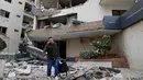 Israel dalam beberapa hari terakhir terus melancarkan serangan udara berturut-turut di wilayah selatan Lebanon. Tampak dalam foto, seorang pria membawa barang-barangnya saat meninggalkan hotel yang rusak akibat serangan udara Israel di Hazmieh, sebelah timur Beirut, Lebanon, Rabu 4 Maret 2026. (AP Photo/Hussein Malla)