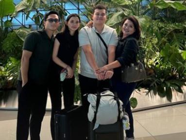 Potret Sarah Menzel berfoto dengan ibunda, kakaknya, dan juga Azriel Hermansyah sebelum keberangkatan. Terlihat mata sembab Sarah karena menangis berpisah sementara dengan Azriel. Tak hanya dari keluarga, Sarah Menzel juga dapat dukungan dari netizen. Pasangan yang terpaut usia 2 tahun ini tampil selaras dan kompak mengenakan baju simpel pakai busana nuansa gelap. (Liputan6.com/IG/@azriel_hermansyah)