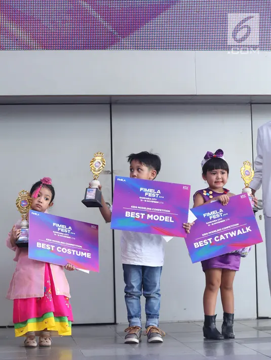 Tiga orang anak berpose dengan piala dan piagam usai menjuarai Kids Modeling Competition dalam acara Fimela Fest 2018, Jakarta, Minggu (18/11). (Fimela.com/Nurwahyunan Nur)
