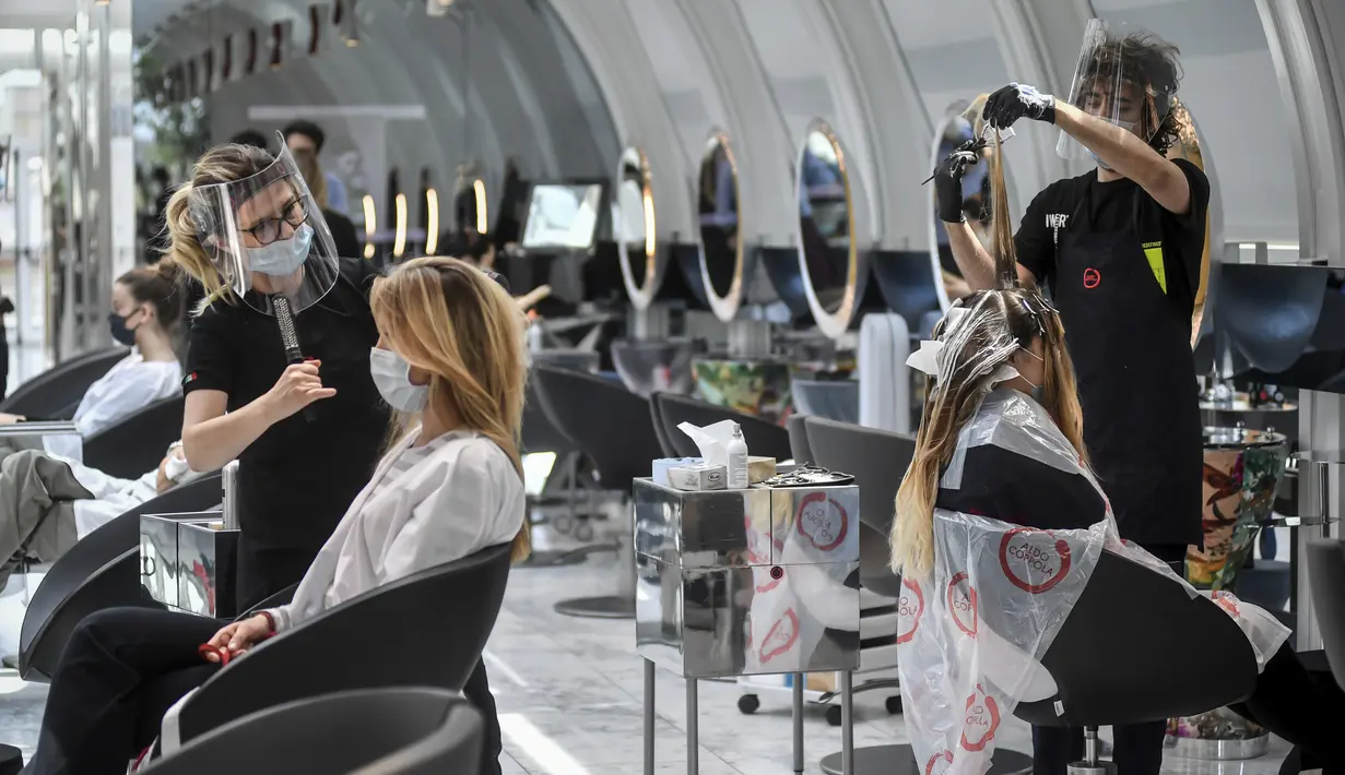 Pengunjung mendapat perawatan rambut di sebuah salon di Milan, Italia, Senin (18/5/2020). Italia secara perlahan melonggarkan kebijakan lockdown akibat pandemi virus corona COVID-19. (Claudio Furlan/LaPresse via AP)