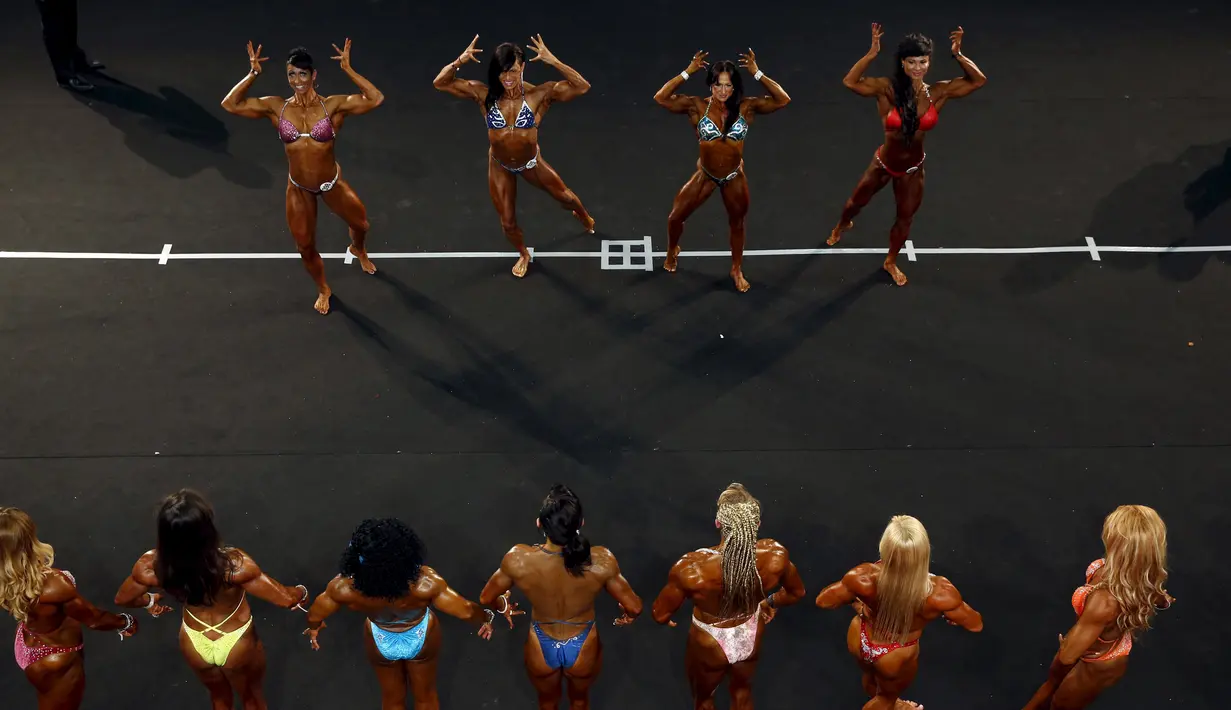 Peserta wanita kontes binaraga menunjukkan lekuk tubuhnya dihadapan penonton dan juri pada kontes Arnold Klasik Eropa 2015 di Madrid, Spanyol, Jumat (25/9). (REUTERS/Susana Vera)