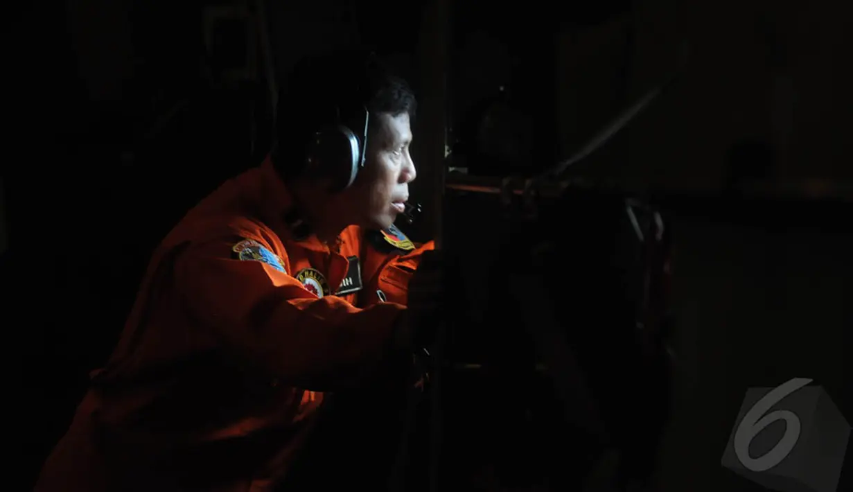 Seorang awak pesawat Hercules C-130 melakukan pencarian pesawat AirAsia QZ8501 di Bangka Belitung, Senin (29/12/2014). (Liputan6.com/Herman Zakharia)