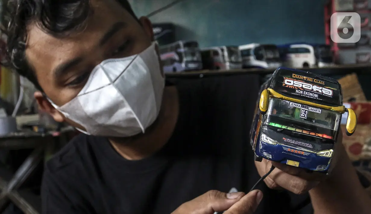 Perajin menyelesaikan pembuatan miniatur bus di Workshop Belang Bentong, Limo, Depok, Jawa Barat, Jumat (14/1/2022). Kerajinan miniatur bus berbahan baku akrilik dan resin tersebut dipasarkan ke berbagai daerah dengan harga Rp 700 ribu hingga Rp 1 juta per unit. (Liputan6.com/Johan Tallo)