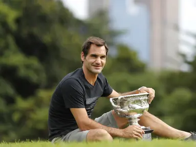 Petenis Swiss, Roger Federer melakukan sesi foto dengan Trofi Norman Brookes Challenge pada Australia Terbuka 2018 di Melbourne, Australia,(29/1/2018). (AP/Ng Han Guan)