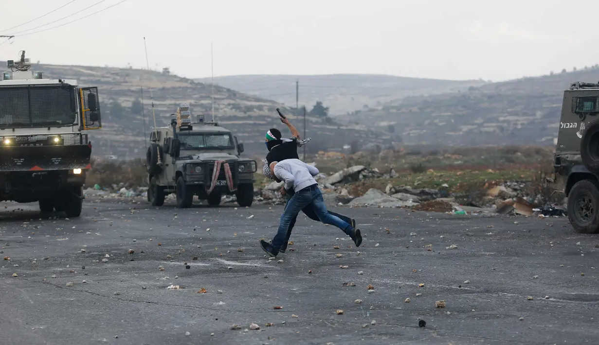 Polisi Israel menangkap seorang demonstran Palestina dalam bentrokan menyusul demonstrasi menentang keputusan Presiden AS, Donald Trump terkait Yerusalem sebagai ibu kota Israel, di kota Ramallah, Tepi Barat, (13/12). (AP Photo / Nasser Shiyoukhi)