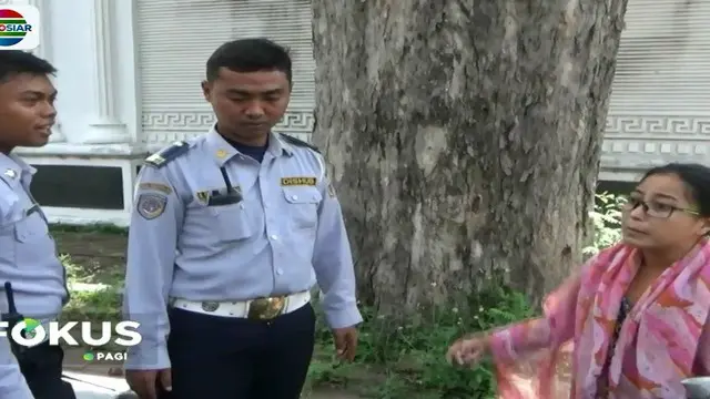 Seorang wanita memprotes petugas Dishub yang hendak menderek mobilnya yang diparkir di depan rumahnya.