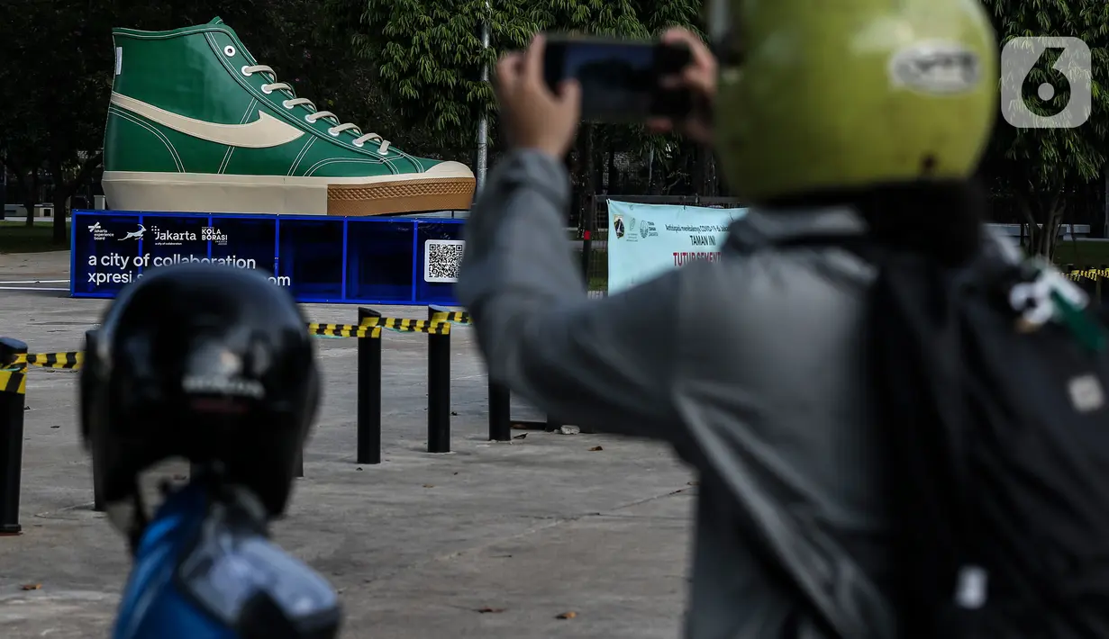 Warga memotret instalasi karya seni kreasi pelaku ekonomi kreatif di Lapangan Banteng, Jakarta, Jumat (17/9/2021). Pemprov DKI memfasilitasi pemasangan instalasi karya seni kreasi pelaku ekonomi kreatif di sejumlah ruang publik Ibu Kota. (Liputan6.com/Johan Tallo)