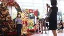 Pengunjung berfoto dengan latar belakang pernak pernik Natal di Living World, Tangerang Selatan, Senin (13/12/2021). Jelang perayan Natal sejumlah pusat perbelanjaan dihiasi ornamen Natal yang dijual. (Liputan6.com/Anga Yuniar)