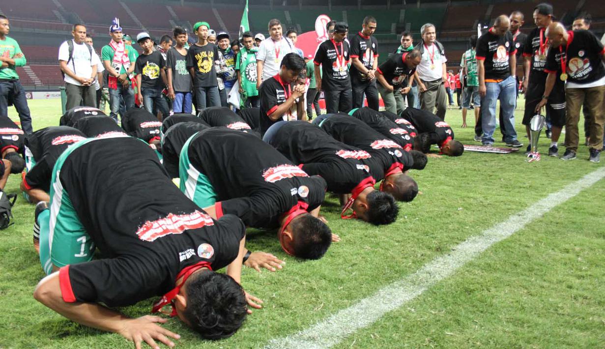 Pemain PSMS sujud syukur usai penobatan juara Piala Kemerdekaan di Stadion Gelora Bung Tomo Surabaya, Minggu (13/9/2015). (Bola.com/Robby Firly)