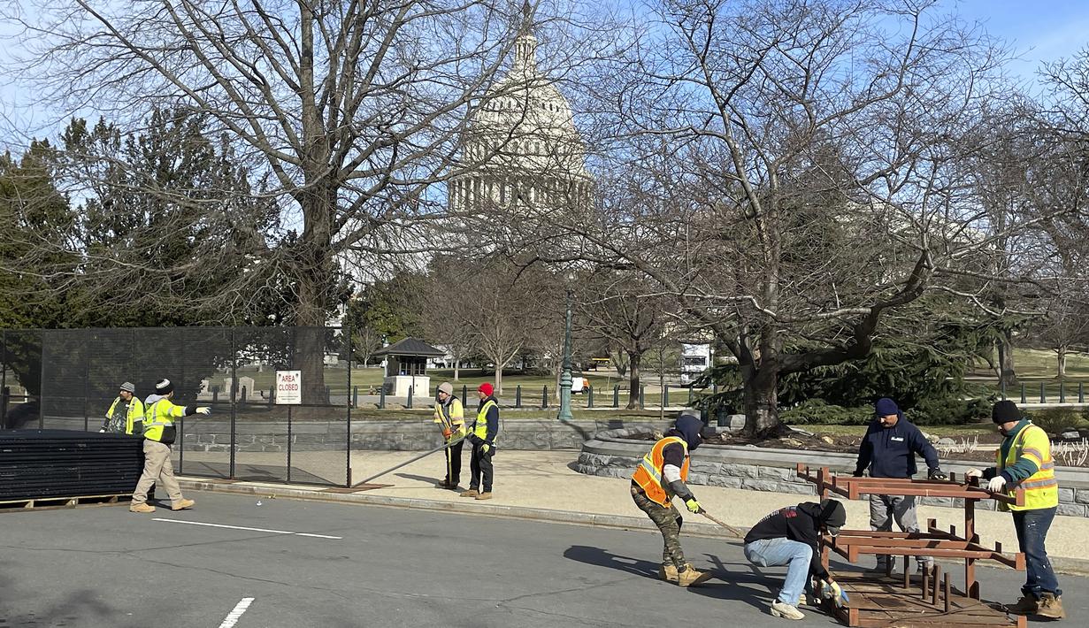 Para pekerja membangun pagar pembatas di sekitar US Capitol, di Washington, Minggu (5/2/2023). Pagar dipasang di sekitar Capitol sebelum pidato kenegaraan atau State of the Union yang akan disampaikan Presiden Joe Biden pada Selasa (7/3) malam waktu AS. (AP Photo/Anna Johnson)