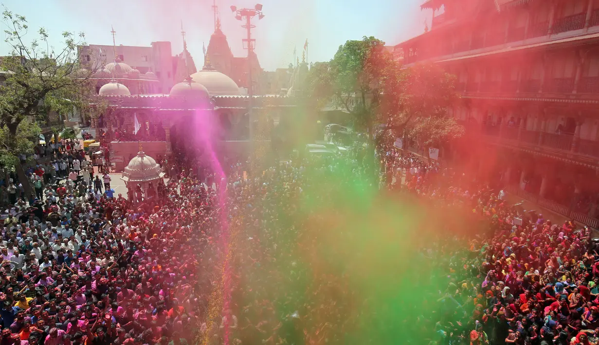 Umat Hindu India berdoa ketika mereka disemprot dengan bubuk berwarna di sebuah kuil selama perayaan Holi di Ahmedabad, Rabu (20/3). Festival Holi atau yang dikenal dengan Festival Warna menjadi ajang untuk saling berbagi cinta. (REUTERS/Amit Dave)