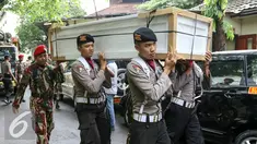 Petugas mengangkat  peti ke ruang transit jenazah yang dipersiapkan untuk korban helikopter TNI yang jatuh di RS Polri, Jakarta, Senin (21/3). Helikopter TNI AD mengalami kecelakaan saat akan mendarat di stadion Poso. (Liputan6.com/Yoppy Renato)