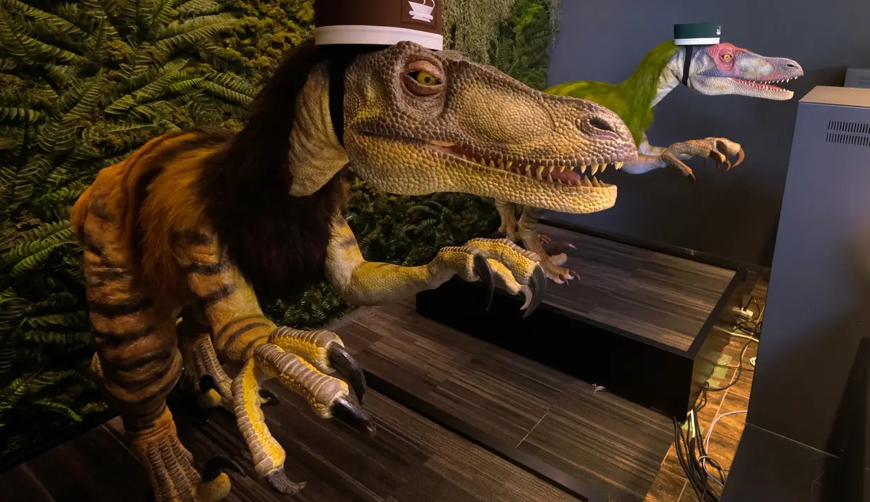 Sepasang robot dinosaurus menyambut para tamu dari meja resepsionis Hotel Henn-na di Urayasu, Tokyo, 31 Agustus 2018. Si robot memiliki bentuk yang persis dengan dinosaurus di film Jurassic Park dengan topi bellboy kecil di kepalanya. (AFP/Kazuhiro NOGI)