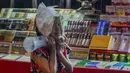 Seorang anak menerjang hujan dengan kantong plastik saat dia mencoba mengumpulkan uang di Bangkok, Thailand, Rabu (17/6/2020). Keseharian warga Bangkok berangsur normal setelah pemerintah terus melonggarkan pembatasan terkait pandemi virus corona COVID-19. (AP Photo/Gemunu Amarasinghe)