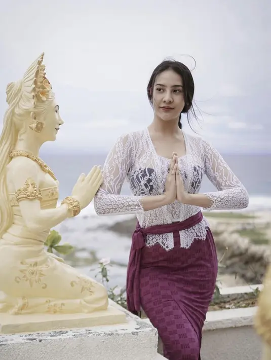 Anya terlihat anggun mengenakan kebaya khas Bali yang berwarna putih dipadukan dengan selendang yang diikat seperti sabuk dengan bawahan kain berwarna magenta. Instagram @anyageraldine