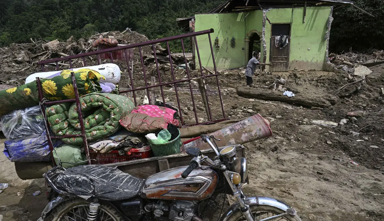Patut diketahui, banjir bandang yang menghantam wilayah Garoga, khususnya di Desa Garoga, Kecamatan Batang Toru, Tapanuli Selatan, Sumatera Utara, menyebabkan kerusakan yang meluas dan parah. Tampak dalam foto, seorang warga mengumpulkan barang-barangnya dari rumahnya yang rusak akibat banjir bandang di Garoga, Provinsi Sumatera Utara, pada Kamis 4 Desember 2025. (YT HARIONO/AFP)