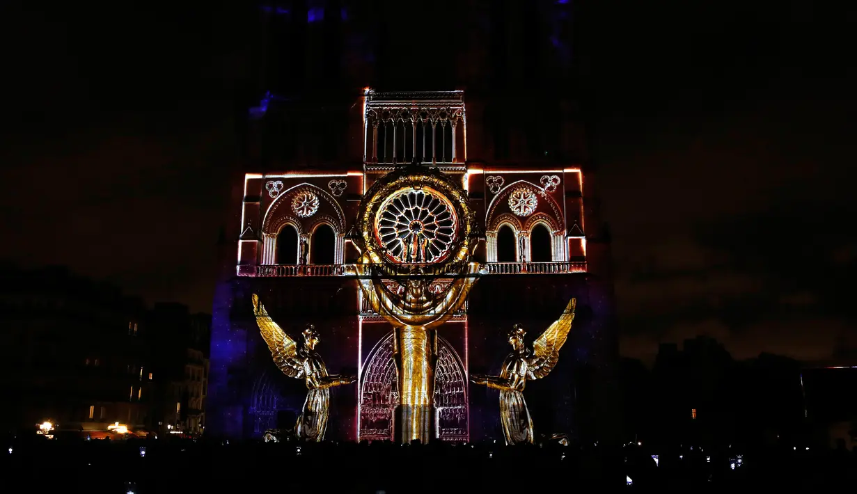 Seni pertunjukan cahaya hiasi Gereja Katedral Notre-Dame de Paris, Prancis (11/11). Pertunjukan cahaya ini dalam rangka peringatan Hari Gencatan Senjata yang menandai berakhirnya Perang Dunia I. (AFP Photo/Francois Guillot)
