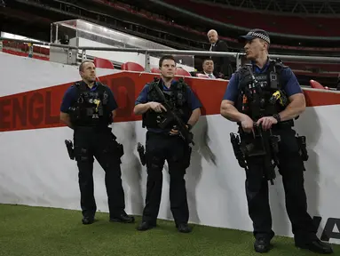 Kepolisian Inggris dengan senjata lengkap menjaga latihan timnas Prancis jelang laga ujicoba melawan Inggris di Stadion Wembley, Inggris, Senin (16/11/2015). (AFP Photo/Adrian Dennis)