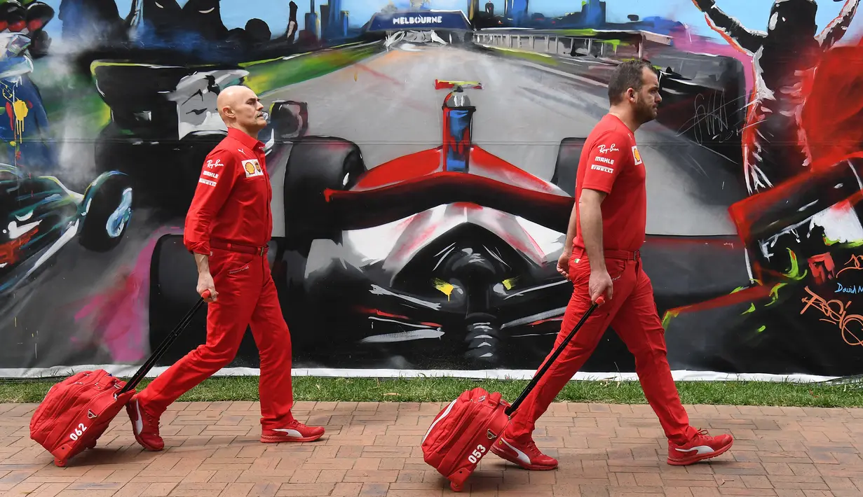Anggota tim Ferrari tiba untuk mengepak peralatan mereka setelah Formula 1 Australia dibatalkan di Melbourne, Jumat (13/3/2020). F1 Australia batal digelar karena virus corona COVID-19. (William WEST/AFP)