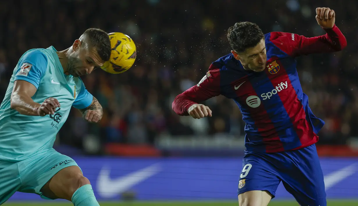 Striker Barcelona, Robert Lewandowski (kanan) dan Mallorca, Matija Nastasic melompat saat perebvutan bola pada laga pekan ke-28 LaLiga 2023/2024 yang berlangsung di Olimpic Lluis Companys Stadium, Barcelona, Sabtu (9/3/2024) dini hari WIB. (AP Photo/Joan Monfort)