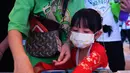 Seorang anak didampingi orang tua bermain puzzle dalam acara perayaan Festival Pertengahan Musim Gugur di Museum Hainan, Haikou, ibu kota Provinsi Hainan, China selatan (1/10/2020). (Xinhua/Guo Cheng)