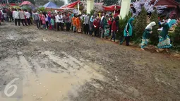 Pengunjung menghindari jalan tanah yang becek pada Festival Lebaran Betawi IX di Lapangan Banteng, Jakarta, Minggu (14/8). Meskipun becek akibat hujan, namun warga tetap antusias mengunjungi festival tahunan tersebut. (Liputan6.com/Immanuel Antonius)