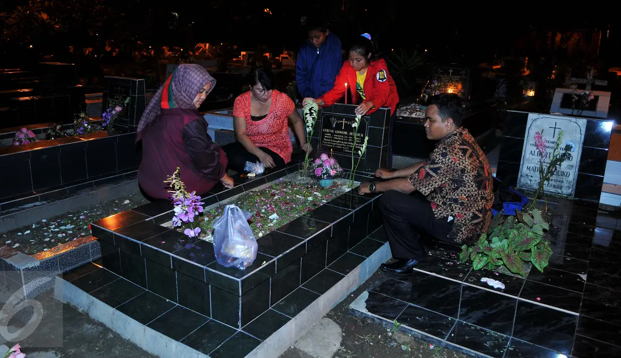 Warga keturunan Portugis melakukan tabur bunga saat ziarah ke makam yang terdapat di sebelah Gereja Tugu, Jakarta, Kamis (24/12). Tradisi nyekar itu dilakukan usai mengikuti ibadah kebaktian malam Natal di gereja. (Liputan6.com/Gempur M Surya)