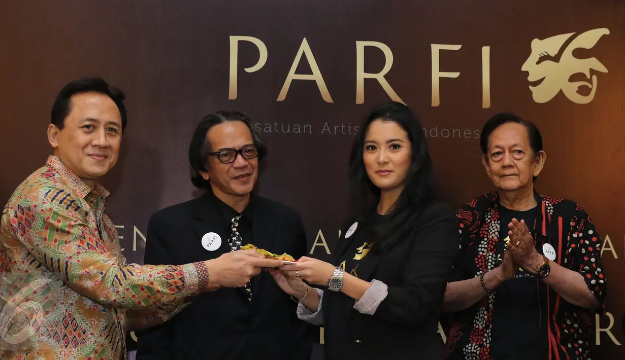 Ketua Badan Ekonomi Kreatif, Triawan Munaf memberikan tumpeng kepada Ketua Umum Parfi 56, Marcella Zalianti saat pengukuhan dan pelantikan pengurus besar PARFI 56 Jakarta, Senin (24/10). (Liputan6.com/Herman Zakharia)