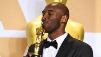 Kobe Bryant mencium Piala Oscar 2018 usai meraih penghargaan di Academy Awards ke-90 di Hollywood, California (3/4). Film animasi mengenai Kobe ini berhasil mengalahkan empat nominasi lainnya. (Jordan Strauss / Invision / AP)
