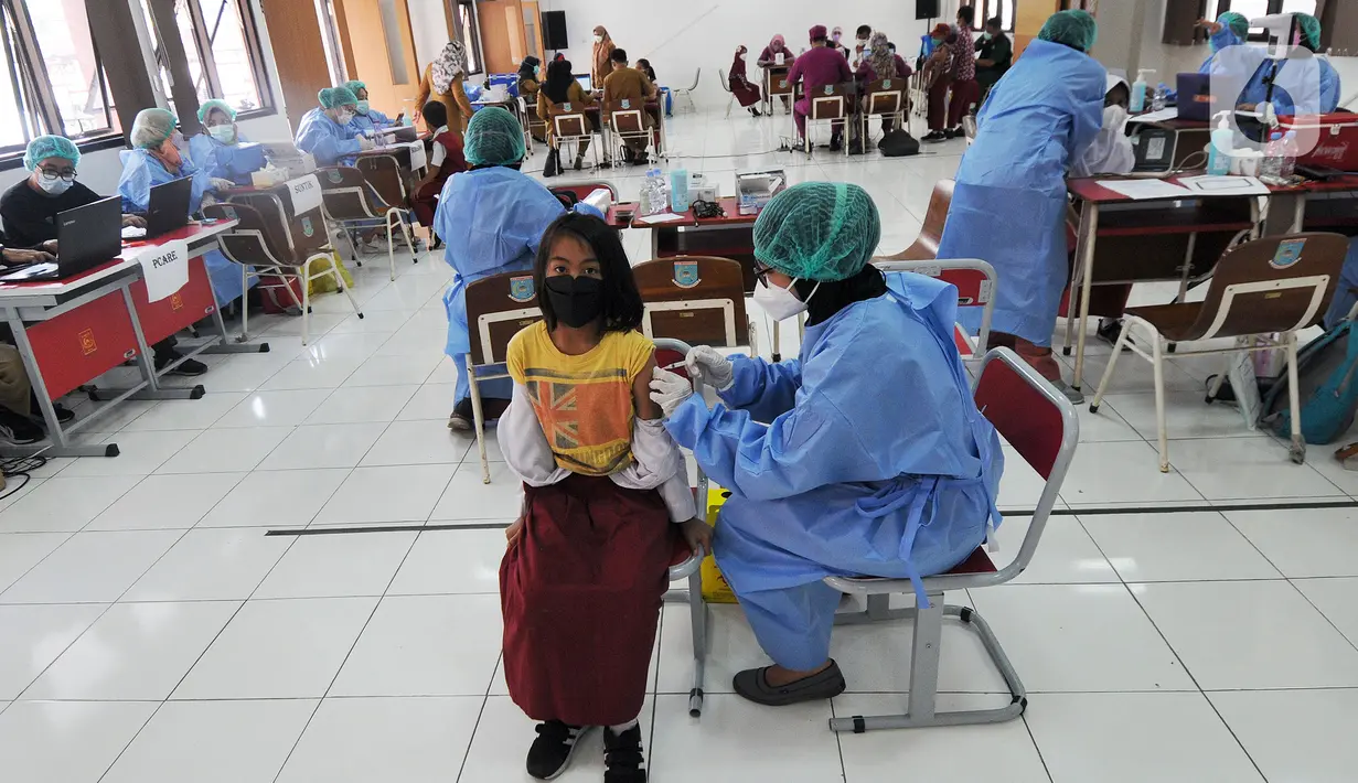 Petugas kesehatan menyuntikkan vaksin COVID-19 kepada siswa di SDN 02 Ciater, Tangerang Selatan, Selasa (14/12/2021). Mulai Hari ini, 11 provinsi di Indonesia secara serentak melaksanakan vaksinasi COVID-19 dengan sasaran anak berusia 6 hingga 11 tahun. (merdeka.com/Arie Basuki)