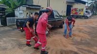 Petugas dari Pertamina Patra Niaga diturunkan membantu pembersihan sisa fame yang tumpah dan mengganggu jalan. (foto: liputan6.com/dok.humas Pertamina Patra Niaga/edhie prayitno ige)