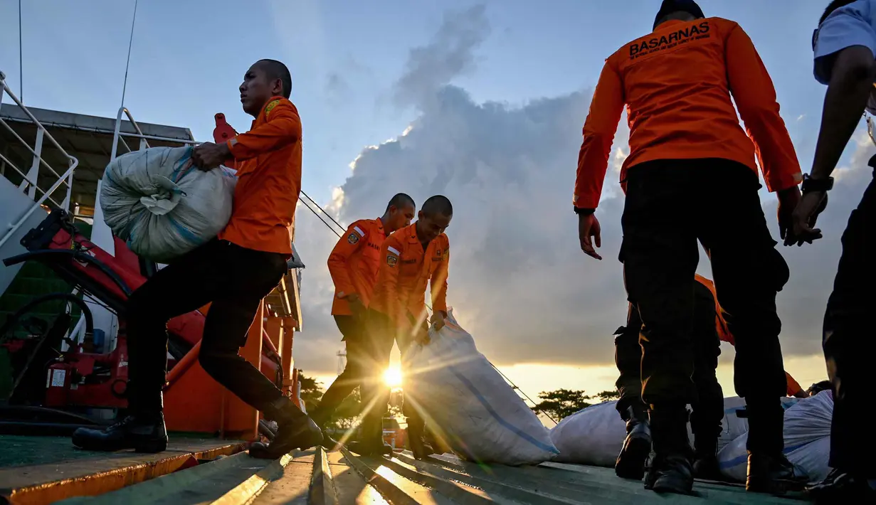 Selain membantu menyalurkan logistik, tim Basarnas terus fokus pada evakuasi warga yang terjebak banjir di lokasi yang sulit dijangkau melalui darat, seperti di Pidie Jaya dan Bireuen. Tampak dalam foto, personel Badan Nasional Pencarian dan Pertolongan (Basarnas) sedang memuat bantuan yang disumbangkan untuk korban banjir bandang di permukiman warga di Banda Aceh, Provinsi Aceh, pada 1 Desember 2025. (Chaideer MAHYUDDIN/AFP)