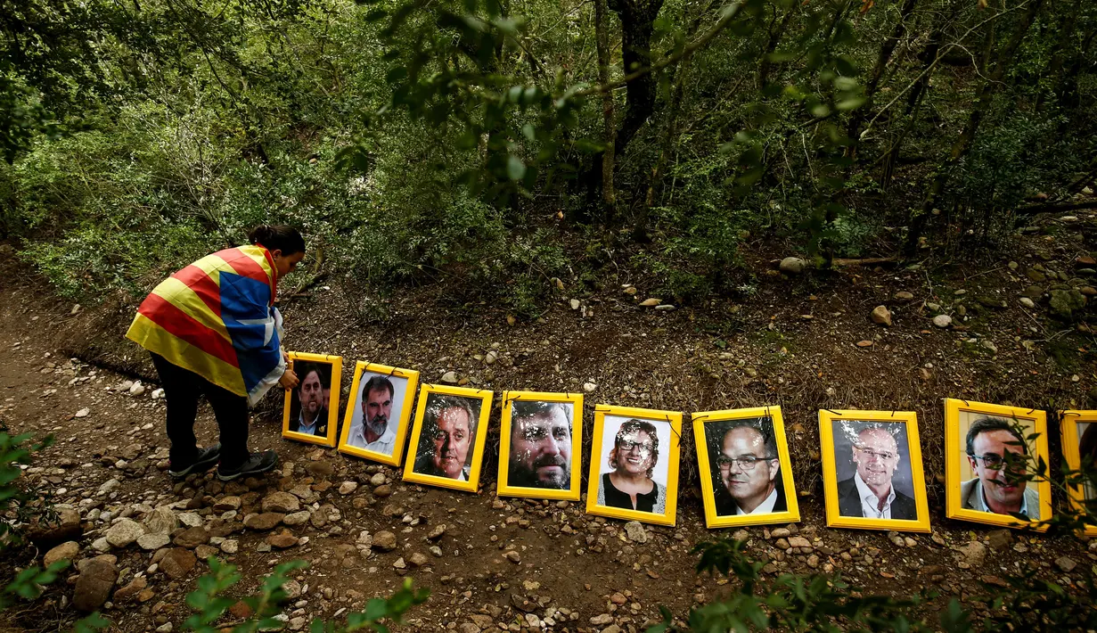 Sejumlah potret orang-orang yang dipenjara dan diasingkan karena mendukung presiden terguling Catalonia, Carles Puigdemont dijejerkan setelah dibawa ke Gunung Montserrat, Spanyol (28/4). (AFP/Pau Barrena)