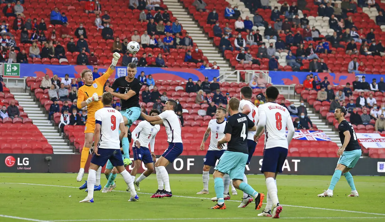 Penjaga gawang Inggris Jordan Pickford meninju bola saat melawan Austria pada pertandingan persahabatan di Stadion Riverside, Middlesbrough, Inggris, Rabu (2/6/2021). Inggris mengalahkan Austria dengan skor 1-0. (Lindsey Parnaby, Pool via AP)