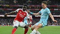 Bukayo Saka mencoba menggocek pemain Burnley. (Glyn KIRK / AFP)