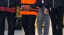 Bupati nonaktif Mamberamo Tengah Ricky Ham Pagawak, berjalan menuju mobil tahanan usai menjalani pemeriksaan di Gedung Merah Putih KPK, Jakarta, Senin (20/2/2023). KPK sempat kesulitan memproses hukum Ricky Ham Pagawak lantaran yang bersangkutan kabur saat hendak ditangkap pada Juli 2022 lalu. (Liputan6.com/Angga Yuniar)