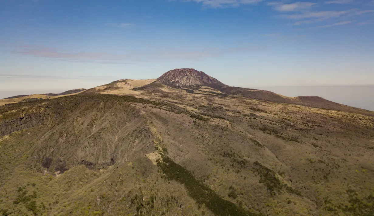 Pemandangan udara Hallasan, atau gunung Halla, di pulau Jeju, Korea Selatan (9/5/2019). Pulau Jeju dijuluki Samdado, "Pulau yang Berlimpah dengan Tiga Hal" yaitu, bebatuan, wanita dan angin. (AFP Photo/Ed Jones)