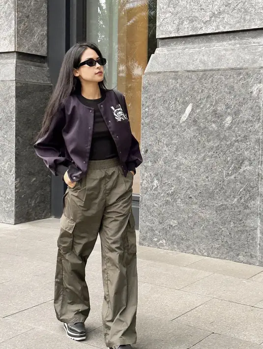 <p>Maudy Ayunda tampil dengan jaket baseball purple dipadu inner hitam dan celana hijau lengkap dengan kantung samping</p>