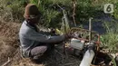 Nasim (67), petani sedang mengairi sawahnya yang dilanda kekeringan di Babelan, Bekasi, Jawa Barat, Selasa (5/9/2023). Nasim memodifikasi mesin pompa air berbahan bakar Pertalite menggunakan bahan bakar gas. (merdeka.com/Imam Buhori)