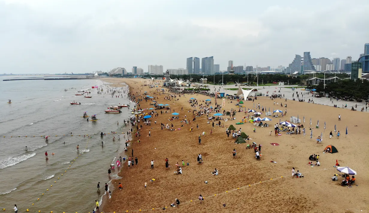 Foto yang diabadikan dari udara pada 9 Juli 2020 ini memperlihatkan orang-orang yang sedang menikmati waktu bersantai di sebuah pantai di Rizhao, Provinsi Shandong, China timur. (Xinhua/Wang Kai)