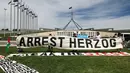 Selama di Australia, Presiden Israel, Isaac Herzog, dijadwalkan akan menghadiri upacara penghormatan bagi korban penembakan di Bondi Beach yang terjadi pada Desember 2025, yang menargetkan perayaan Hanukkah. Tampak dalam foto, para pengunjuk rasa berkumpul di depan gedung Parlemen menjelang pertemuan antara Perdana Menteri Australia Anthony Albanese dan Presiden Israel Isaac Herzog di Canberra pada Rabu 11 Februari 2026. (David GRAY/AFP)
